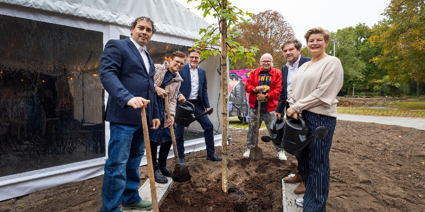 Richard Prins (bestuurder Parnassia, links achter), Wilfried Stribos (directeur-bestuurder van Arcade, tweede van rechts) en Mariëlle Vavier (wethouder Armoede, Inclusie, Zorg en Internationale Zaken gemeente Den Haag, rechts) planten samen met enkele bewoners de eerste boom.